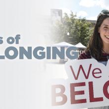 Woman holding a sign that reads "We All Belong"