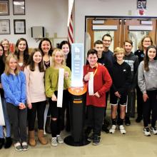 Members of the Glen Ellyn Library Foundation Board, library staff and Glen Crest students stand around the Short Story Kiosk.